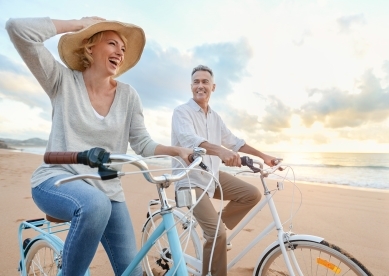 Couple riding bikes on beach